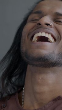 Slow motion portrait of happy Indian man laughing looking at camera on black color background. Joyful person and positive emotion concept.