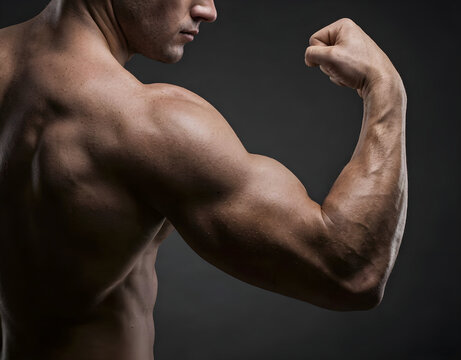 Close-up of an athletic man flexing strong bicep and back muscles against a dark grey background.