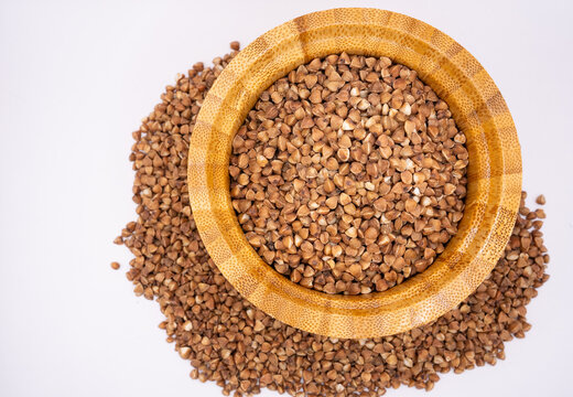 Buckwheat Groats in Wooden Bowl on Light Background