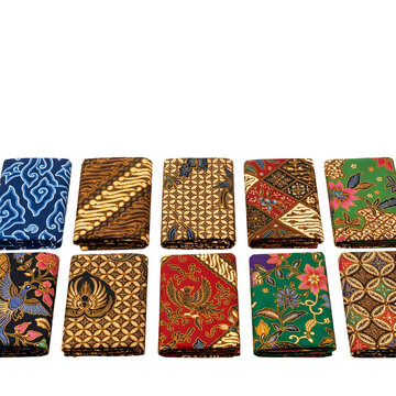 Set of ten folded patterned batik fabric pieces on transparent background