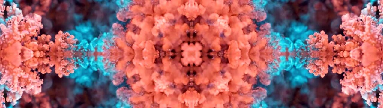 Ink flow and kaleidoscope pattern orange and blue liquid pigment mixing in water slow motion fluid motion background for creative design.