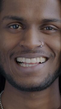Slow motion portrait of stylish Indian man smiling looking at camera on black background. Positive emotion and individuality concept.