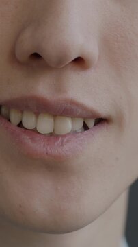 Close-up slow motion portrait of male mouth smiling expressing pleasure on black background. Positive emotion and human body part concept.