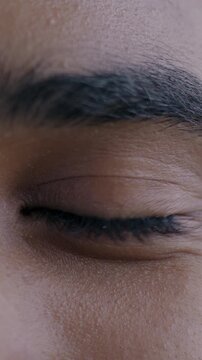 Close-up portrait of male eyes while African American young man looking at camera with joy. Positive emotion and face expression concept.