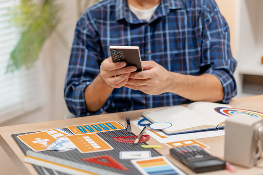 Designer working with color palettes, layout templates, and creative design tools on a desk while planning branding and graphic design projects in a modern office.