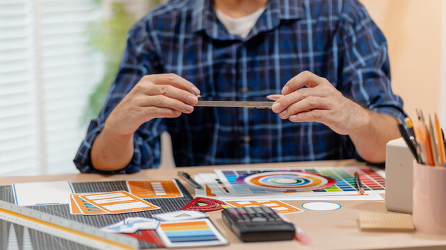 UX UI designer reviewing color palettes, interface components, and design assets while planning a user-centered digital product in a creative workspace.