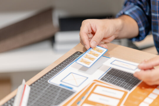 UX UI designer reviewing color palettes, interface components, and design assets while planning a user-centered digital product in a creative workspace.