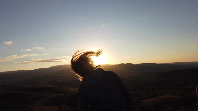 Long haired man wild free spirit dance at sunset in the mountains 