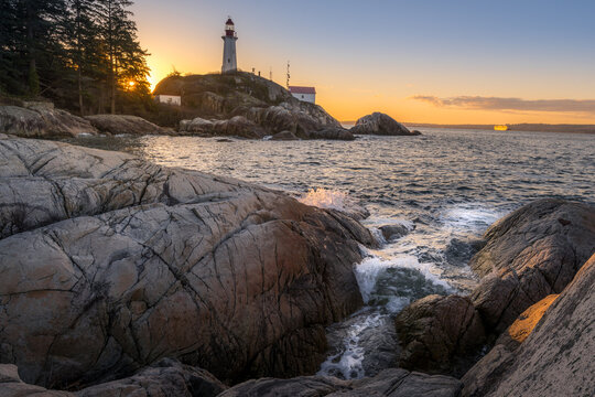 Point Atkinson Lighthouse on a rocky shore at sunset, West Vancouver, British Columbia, Canada