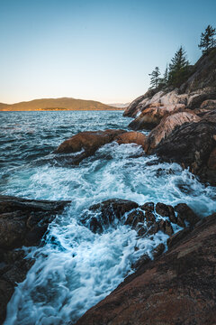 Waves washing over rocks on the shoreline near Point Atkinson Lighthouse, West Vancouver, BC, Canada