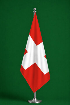 3D illustration. Flag of Switzerland on a ceremonial standing flag on a pole with a metal base.
