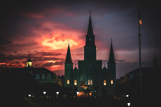 Saint Louis Cathedral silhouetted against a fiery red sunset sky after a storm, New Orleans, Louisiana, USA