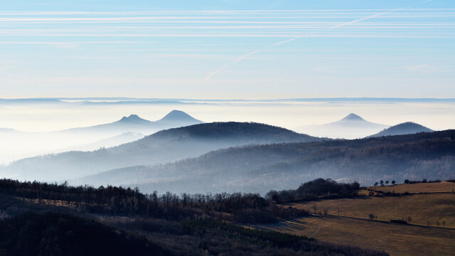 Panoramic view of volcanic peaks rising above a dense white morning mist