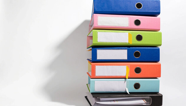 Colorful ring binders stacked vertically in organized pile, featuring blue, pink, green, orange, and black folders on white background, symbolizing office organization and productivity