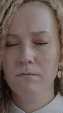 Slow motion portrait of nervous and insecure young lady looking at camera on black background. People and negative emotion concept.