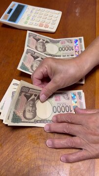 お金を振り分ける高齢者の手