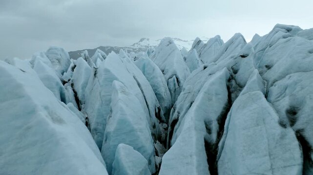 Skaftafellsjokull outlet glacier in Vatnajokull National Park, Southeast Iceland, with deeply fractured ice, seracs and glacial flow structures, drone forward flyover