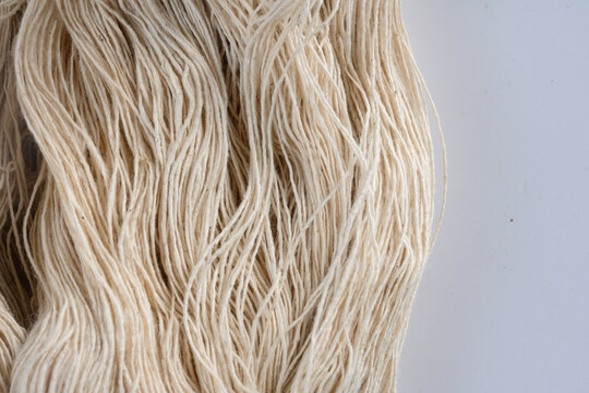Natural fiber beige yarn textile material closeup soft texture craft supply thread weaving handmade organic neutral color background