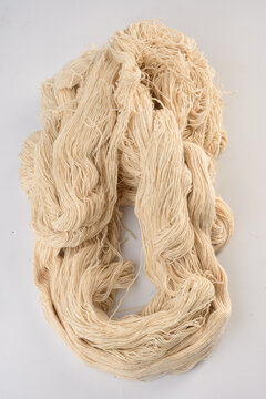 Natural cotton yarn cream color soft texture textile material used for knitting weaving or crafting isolated on white background traditional fiber handmade supply