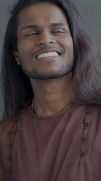Slow motion of Indian man in traditional clothes dancing enjoying music on black background. Festive mood and people concept.