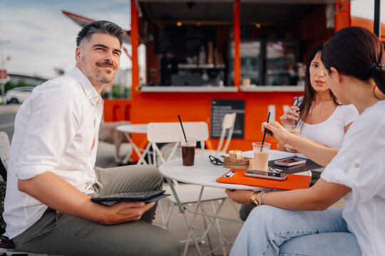 Casual business meeting outside food truck with friends