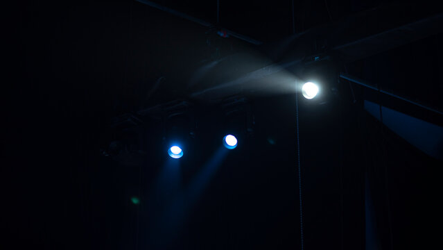 Blue and white сoncert spotlights on stage truss with copy space