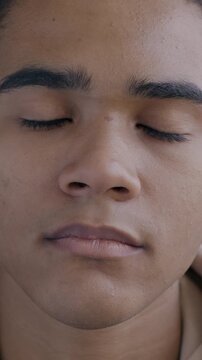 Slow motion portrait of serious young African American man looking at camera on black background. Individual style and face expression concept.