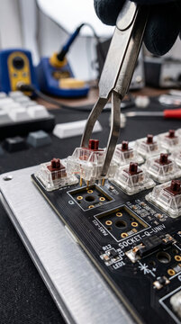 Angled close up view of individual mechanical keyboard switches mounted into hot swap sockets on an electronic PCB circuit board for enthusiast typing builds.