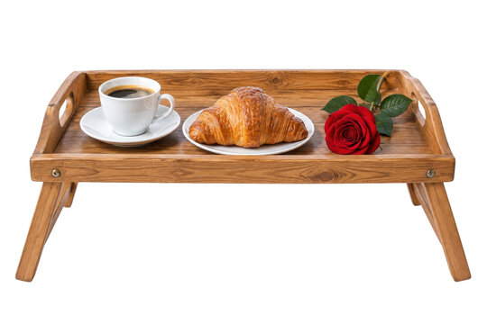 Delicious breakfast in bed with a fresh croissant, hot coffee, and a single red rose on a wooden tray