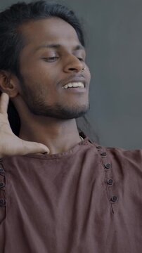 Slow motion of Indian man taking selfie with smartphone camera posing laughing on black color background. People and photo concept.
