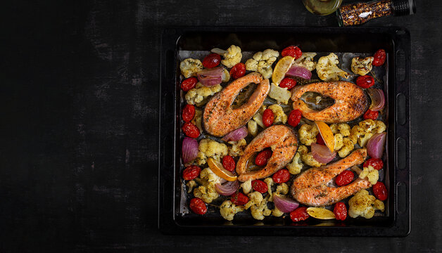 Baked Salmon with Cauliflower, Tomatoes and Red Onion on Sheet Pan. Top view