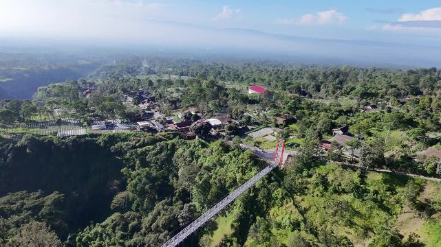 Aerial drone view of Girpasang suspension bridge with majestic Mount Merapi volcano background in Tegalmulyo, Klaten, Indonesia