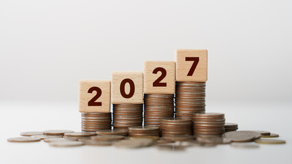 Stacks of coins with wooden blocks forming number 2027 for target financial growth, investment planning, money savings to wealth, business goals concept. Budget and tax, Happy new year 2027 © Anon