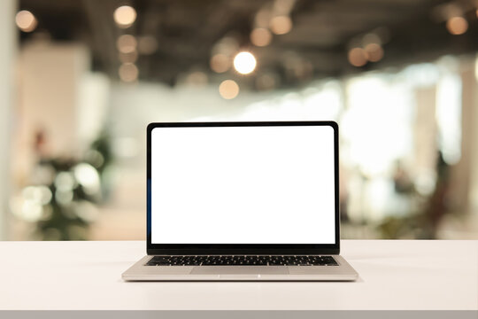 close up isolated on blank white screen display of laptop computer on table inside office room for add content of design banner , website or template or online shopping e-commerce concept
