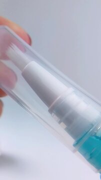 Close up of opening nail moisturizer product cap with small brush applicator. Nail care treatment and manicure concept for healthy protected nails.