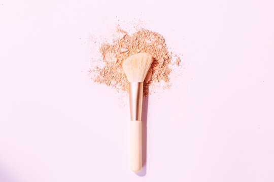 Make up brushes with powder on white background
