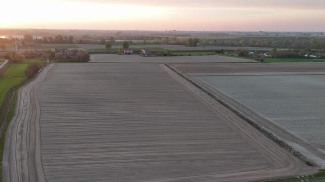 Po Valley cultivated farmland in Italy with precise parallel soil rows and prepared agricultural plots, showing intensive mechanized field management, drone slide