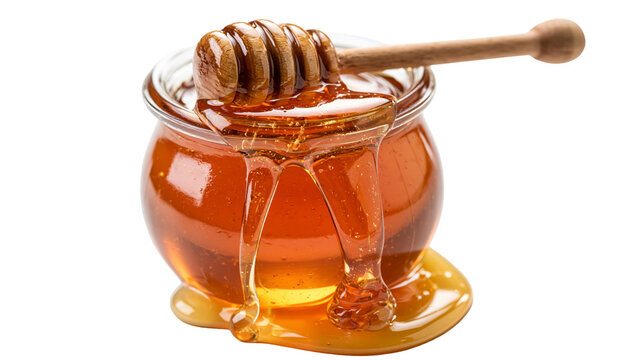 Golden liquid honey in a glass jar with a wooden honey dipper resting on top