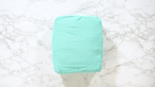 Hands holding folded turquoise kids bedding