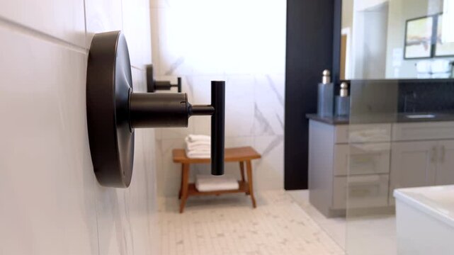 Black shower hardware on marble tile wall