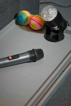 Colorful balls and a microphone on a tray with a light source in a room setting