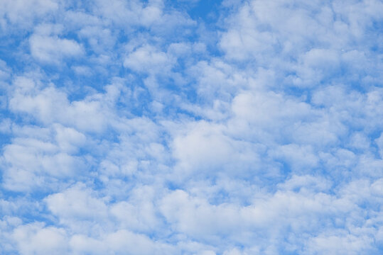 Clouds float in a blue sky during daytime with soft shapes and various patterns