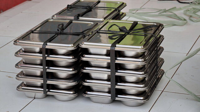 Metal MBG containers with fitted lids are tied in stacks for meal transport and free food distribution in Indonesia for schools for students