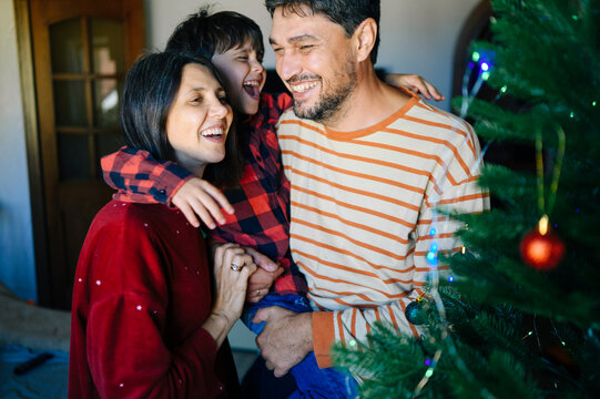 A happy family celebrates Christmas together by the decorated tree