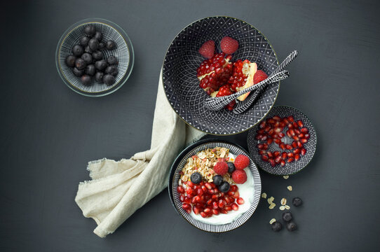 Muesli with pomegranate seeds and different berries in bowl
