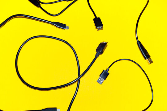 Black USB cables cover a bright yellow background