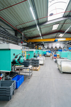 Modern machinery stands inside an empty industrial production hall