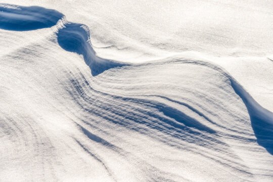 A close-up shows a patterned snowdrift in South Tyrol
