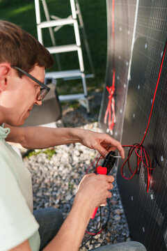 Man installing solar panel wiring at a campsite for his camper