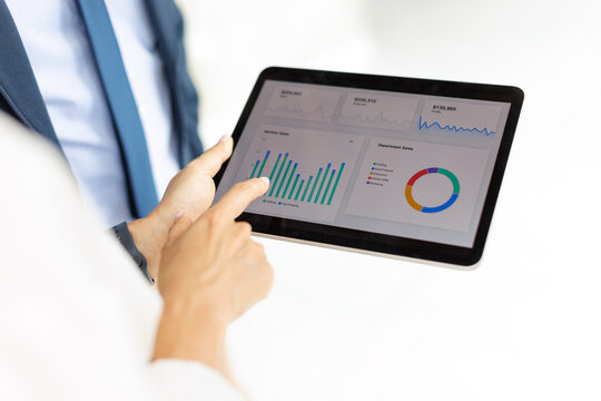 Business professionals analyze financial charts on a tablet